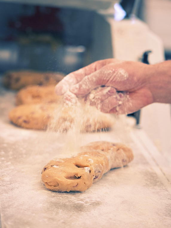 Hand throwing flour on dough